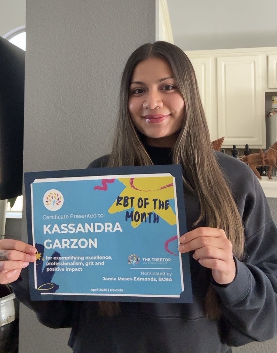 Kassandra Garzon holding her BT of the Month certificate